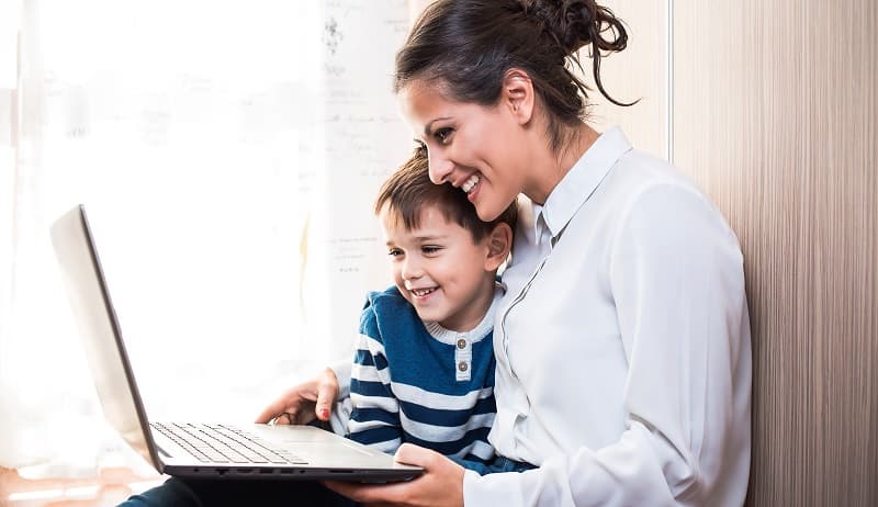 img 1: “Madre con il suo bambino navigano su internet da pc portatile”
