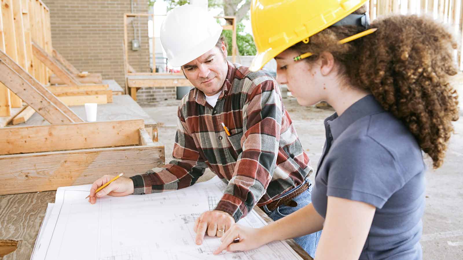 Apprendistato: una giovane apprendista in cantiere assieme a un collega