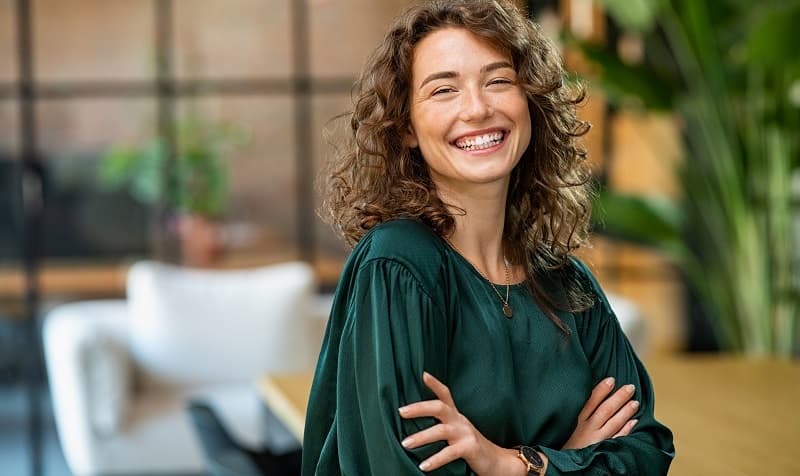 img 1: “Giovane donna sorridente sul luogo di lavoro”