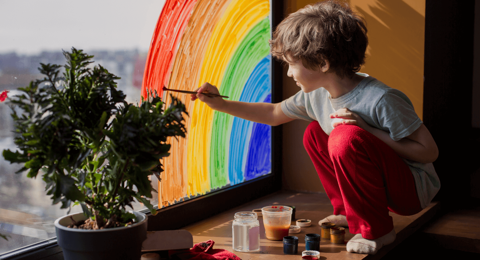 img. 1: “Un bimbo disegna un arcobaleno sul vetro di una finestra”