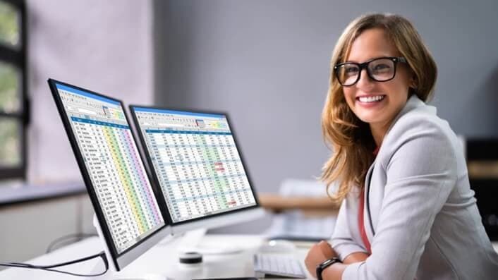 img 1: “Impiegata analizza dei fogli di lavoro Excel”