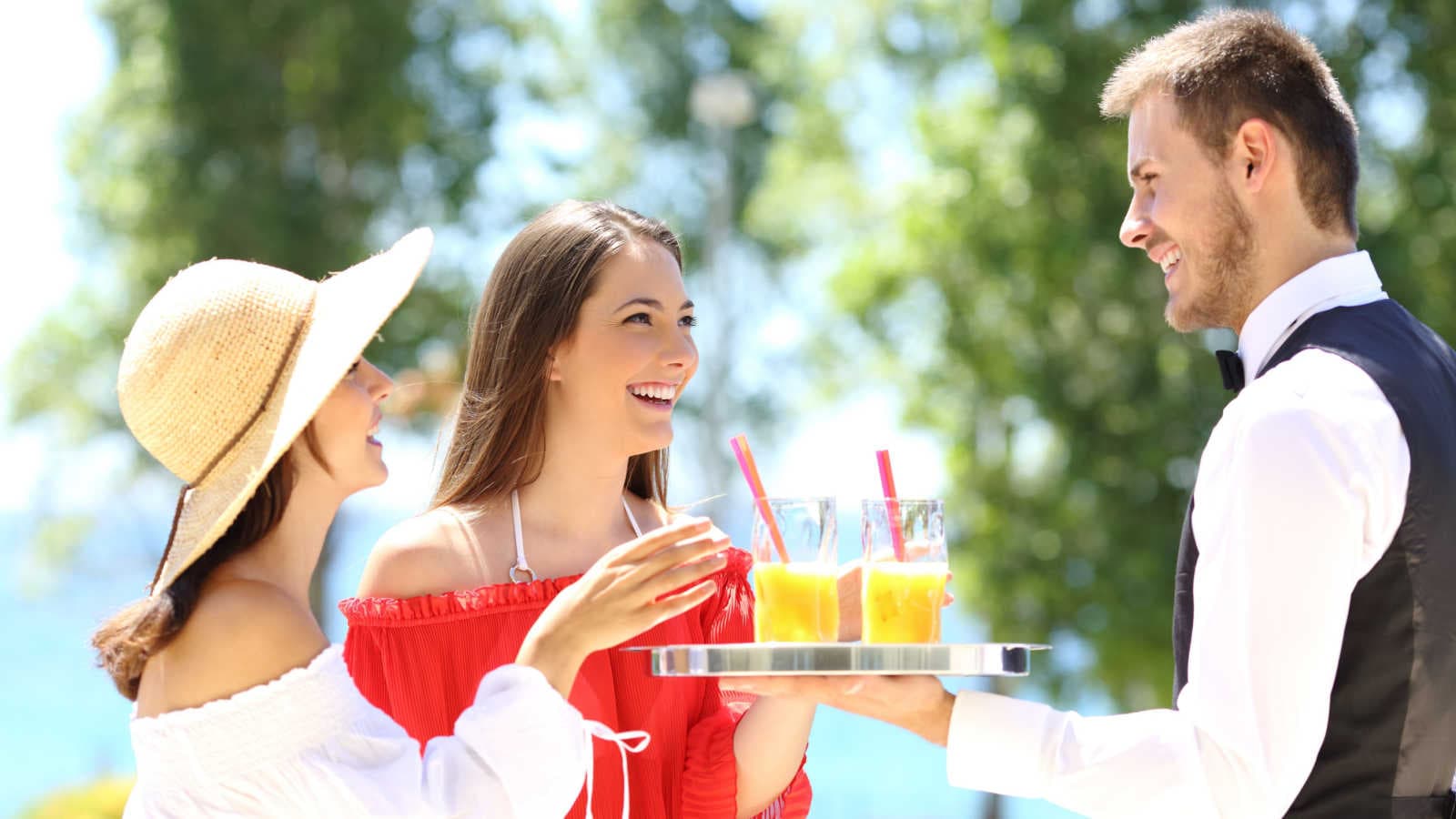 Cameriere serve turiste in vacanza