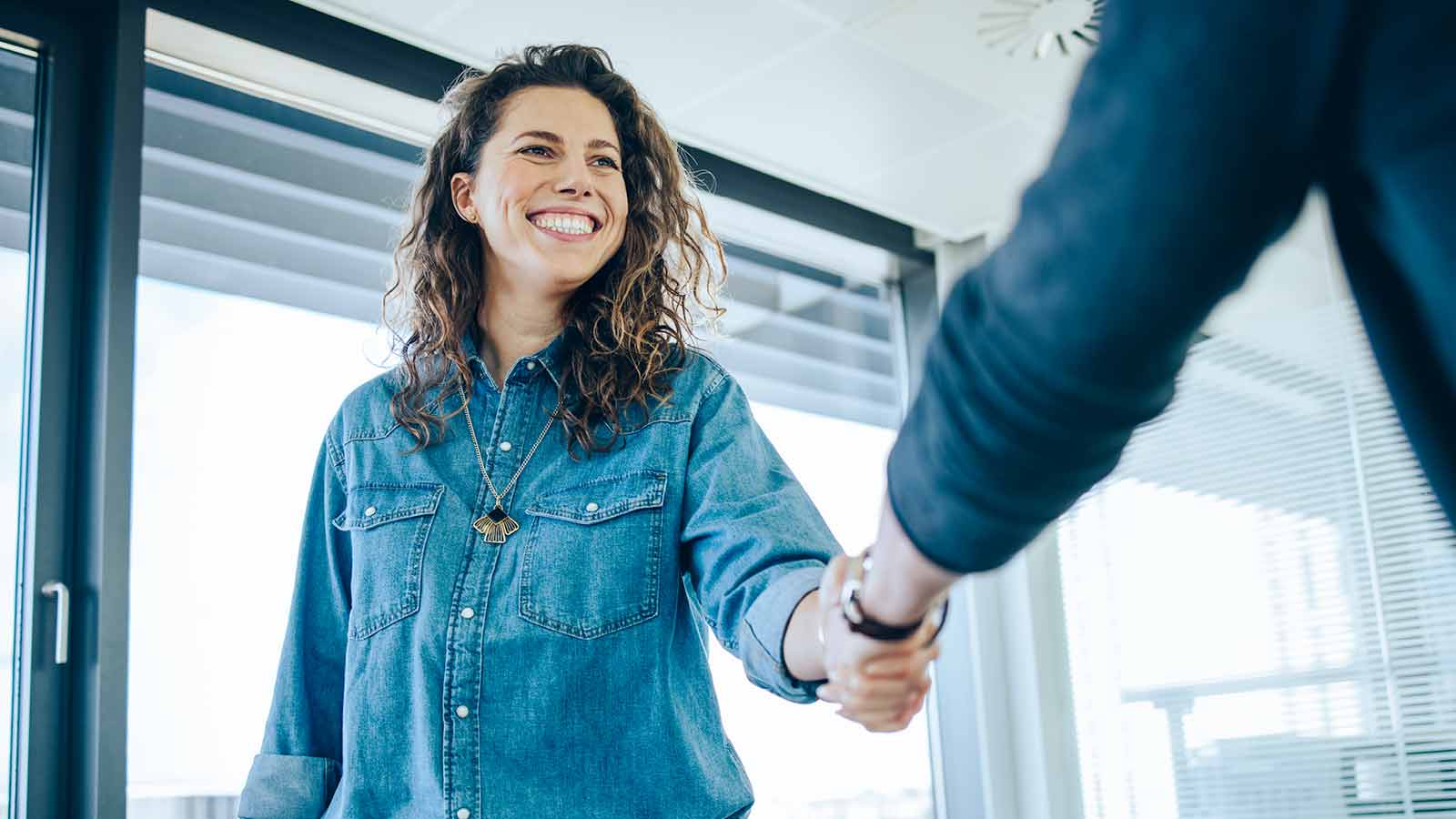 incentivi e agevolazioni assunzioni: donna stringe la mano al futuro datore di lavoro